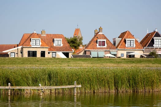 Historic houses behind te dike in Makkum, the Netherlands..