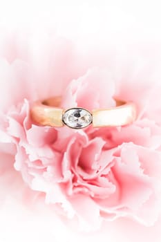 Wedding or engagement ring in a flower. Symbol of love. Soft focus.