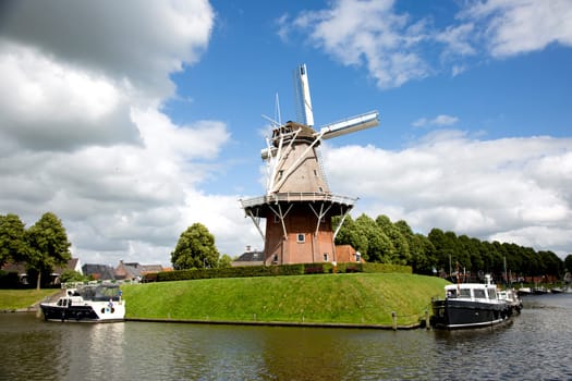 Dokkum, Friesland, The Netherlands - Jun 30, 2019  Boats on canal and windmill on fortifications of historic town Dokkum, Friesland, The Netherlands..