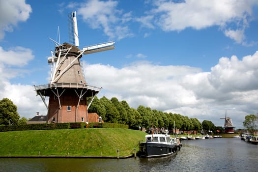 Dokkum, Friesland, The Netherlands - Jun 30, 2019  Boats on canal and windmill on fortifications of historic town Dokkum, Friesland, The Netherlands..