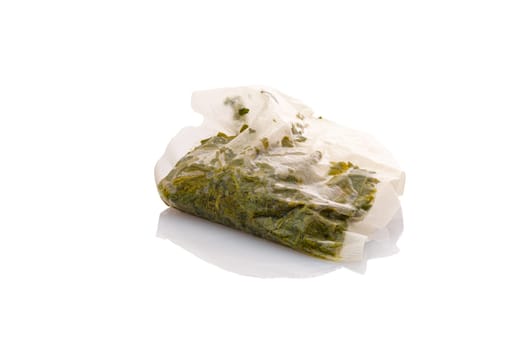Wet green tea bag close-up white isolated