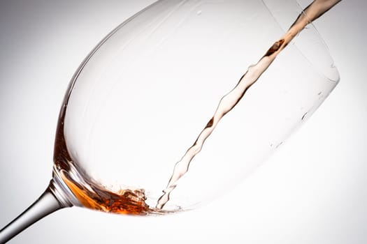 Pouring rose wine in a glass close-up