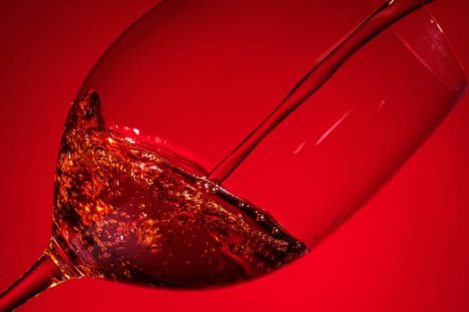Pouring red wine in a transparent glass