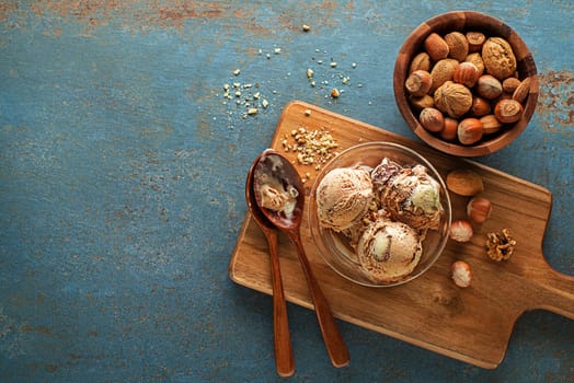 Homemade Organic Ice cream scoops with chocolate and nuts in bowl close up