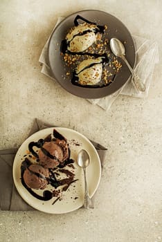 Set of ice cream scoops with chocolate and vanilla flavours. Chocolate syrup topping on ice cream