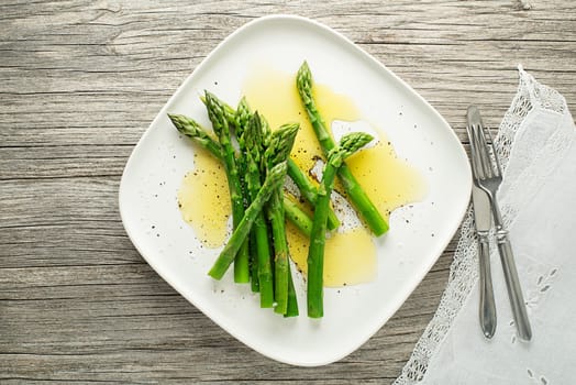 Asparagus. Green asparagus. Fresh boiled Asparagus with dressing sauce on plate close up