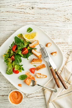 Eating Healthy green salad meal with crispy fried breaded chicken breast strips and tomatoes