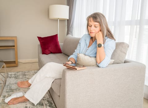 Mature woman looking at a tablet screen in her urban apartment