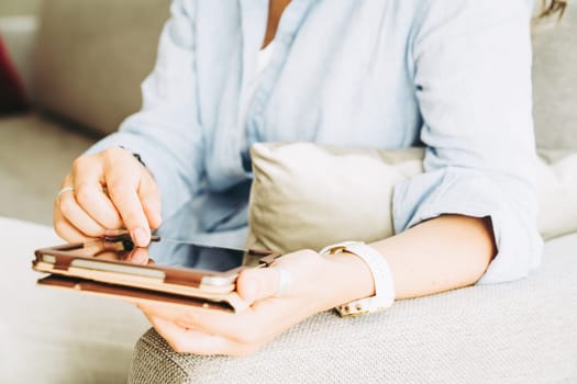 Close-up of woman's hands holding tablet PC and a stylus pen