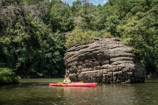 Kayaker looking at a rock formation on Grayson Lake in Kentuky
