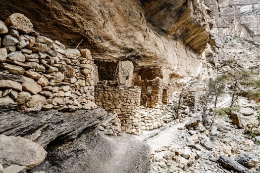 Ancient stone cliff dwellings in Wadi Ghul in Oman