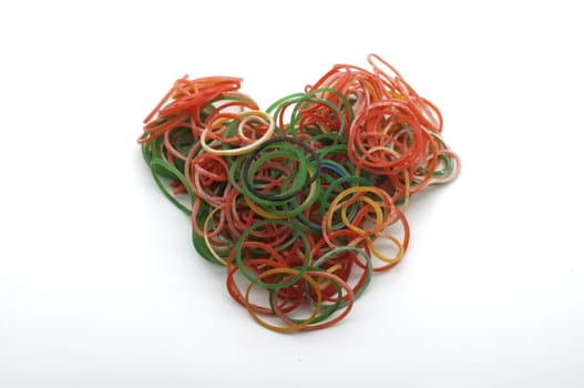 Colorful rubber bands for making rainbow loom bracelets in heart shape isolated on white background