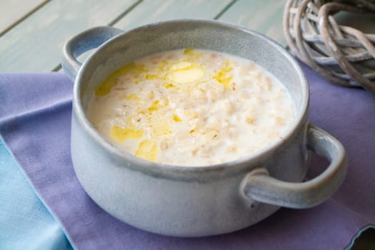 Milk soup with dough on wooden table close up