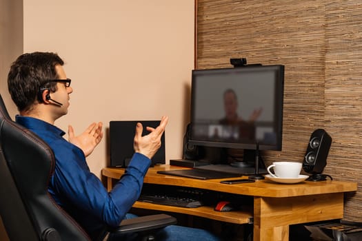 Businessman talking on video conference with coworkers from comfort of his home during covid 19 or coronavirus pandemics, lockdown and quarantine