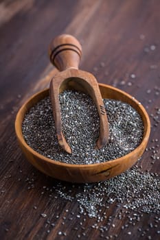 Nutritious Chia seeds with spoon in the bowl on the wooden background