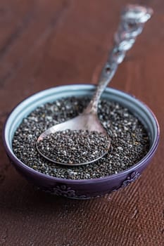 Nutritious Chia seeds with spoon in the bowl on the wooden background