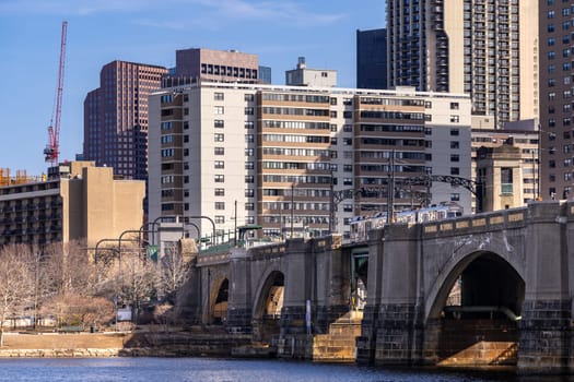 Tram Transportation to Cambridge side over bridge of Charles River with Cityscape of Boston Downtown skyscraper skylines office buildings. Boston is in Commonwealth of Massachusetts New England USA.