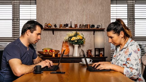 Men and woman, couple, working on computers from comfort of their home during covid 19 or coronavirus pandemics, lockdown and quarantine