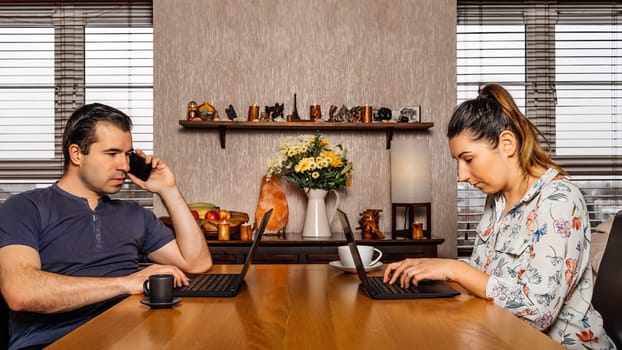 Men and woman, couple, talking and working on computers from comfort of their home during covid 19 or coronavirus pandemics, lockdown and quarantine