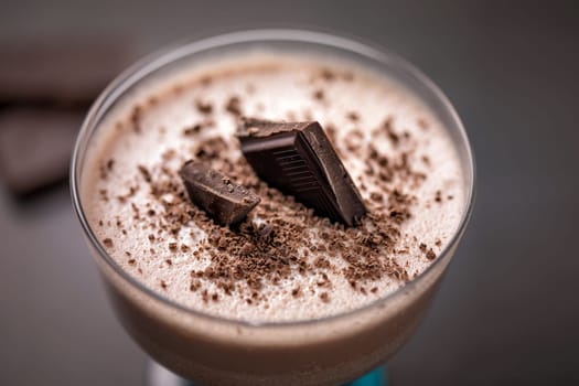 Chocolate curd dessert decorated with chocolate chips and pieces of chocolate