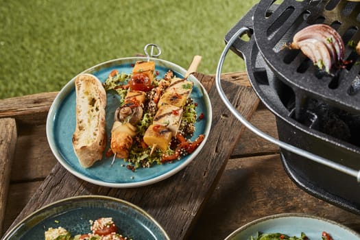 A close up of plates of gourmet barbecued vegetarian food in an outdoor setting.