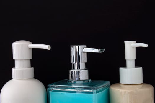 Close up top view of colorful soap dispenser for bathrooms or kitchen sinks on a black background