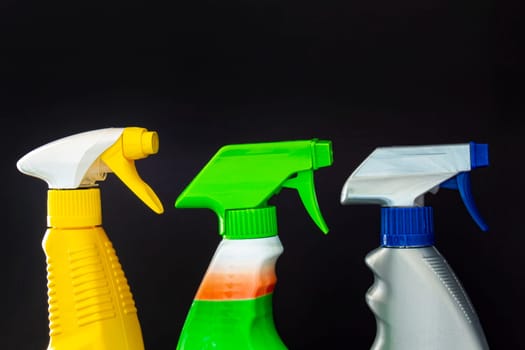 Close up of spray cleaners bottles on a black background