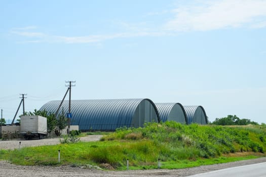 Large hangars made of galvanized corrugated sheet iron.