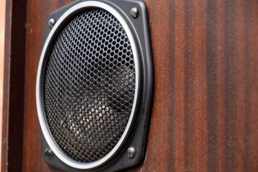 Mid-range speaker with a protective grid on the speaker.