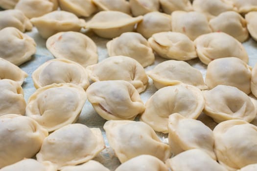 Blinded homemade dumplings lie on the table