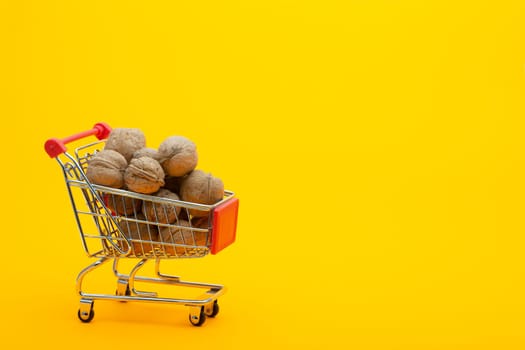 Walnuts are in the grocery basket, bright orange background