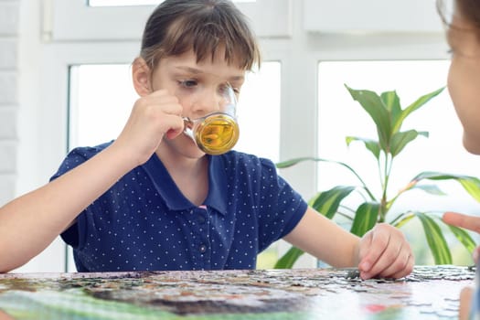 Girl drinks water playing board games at the table