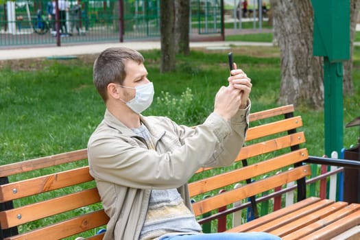 A man in a medical mask is photographed on the phone