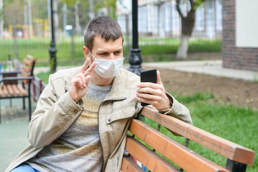 A man in the park communicates with friends via video calling
