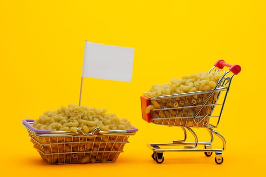 The cart and the basket are filled with pasta on a bright orange background, a flag is stuck in the basket