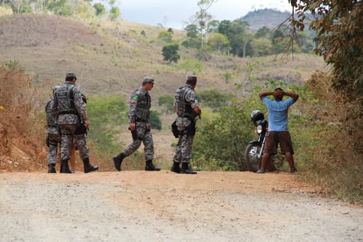 pau brasil, bahia / brazil - may 3, 2012: National Force military personnel approach vehicles and people traveling in rural Pau Brasil  after armed conflict between Pataxo Hahahae ethinics and farmers.