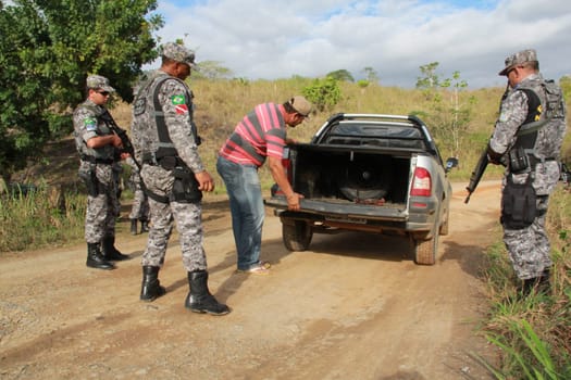 pau brasil, bahia / brazil - may 10, 2012: National Force military personnel approach vehicles and people traveling in rural Pau Brasil after armed conflict between Pataxo Hahahae ethinics and farmers .