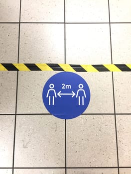 social distancing for Coronavirus covid-19 supermarket floor tape line to government guidelines for distance to avoid spread of virus pathogen
