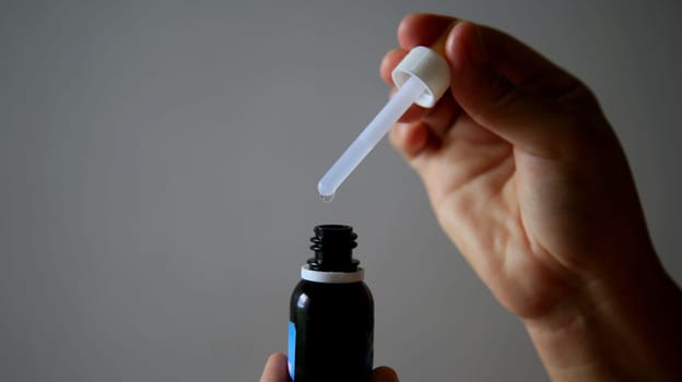 salvador, bahia / brazil - may 7, 2020: hand removes weak medication with the aid of a dropper.