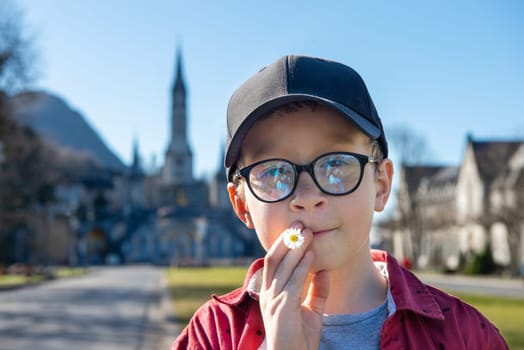 a young boy with the basilica of Lourdes in France