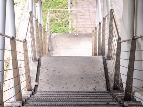 staircase for descending from footbridge. The concrete overpass for crossing the road.