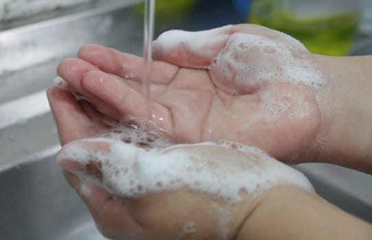 salvador, bahia / brazil - january 11, 2015: Person Washing Hands in Kitchen Sink. Very effective hygiene measure against Corona Virus...