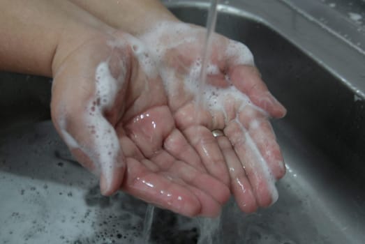 salvador, bahia / brazil - january 11, 2015: Person Washing Hands in Kitchen Sink. Very effective hygiene measure against Corona Virus...