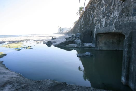 salvador, bahia / brazil - january 12, 2015: Sewerage and view pouring fluids on the sand of Amaralina beach in Salvador.