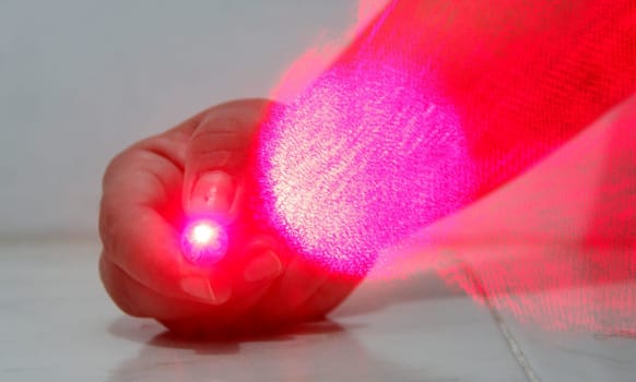 salvador, bahia / brazil - october 13, 2014: Hand holds toy that emit laser beams. The equipment can cause eye damage if the beam is directed into the eyes.