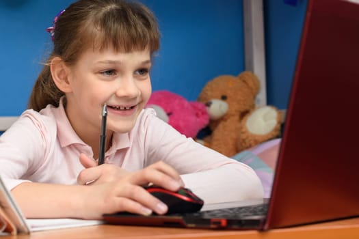 Happy girl at home performs online homework