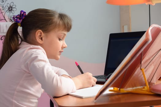 Side view of a girl who is studying remotely at home