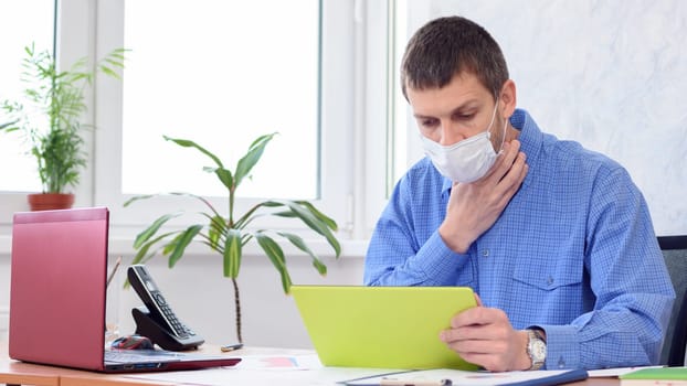 Ill employee in the office holds his throat