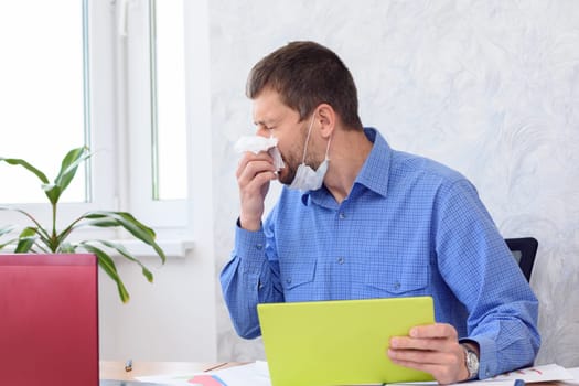 A sick employee sneezes in an office and works remotely