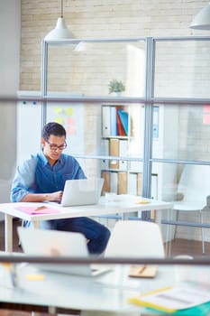 Businessman in casualwear browsing with laptop in office